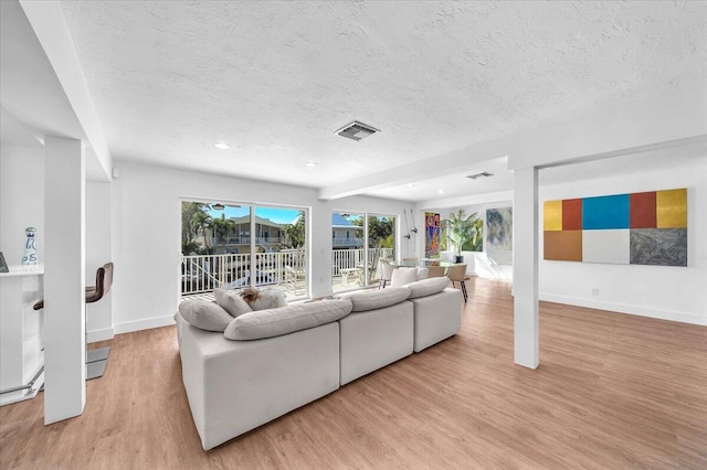 living room featuring light hardwood / wood-style flooring and a textured ceiling