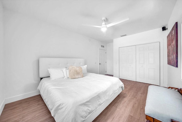 bedroom with wood-type flooring, ceiling fan, and a closet