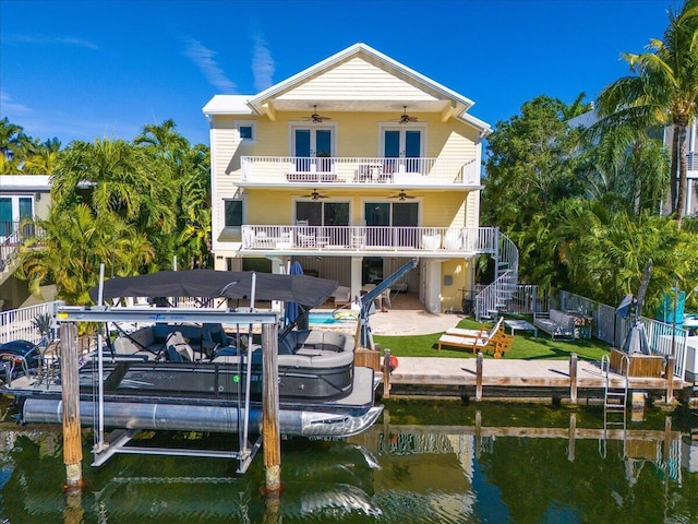 back of house featuring a balcony, a water view, ceiling fan, and a patio area