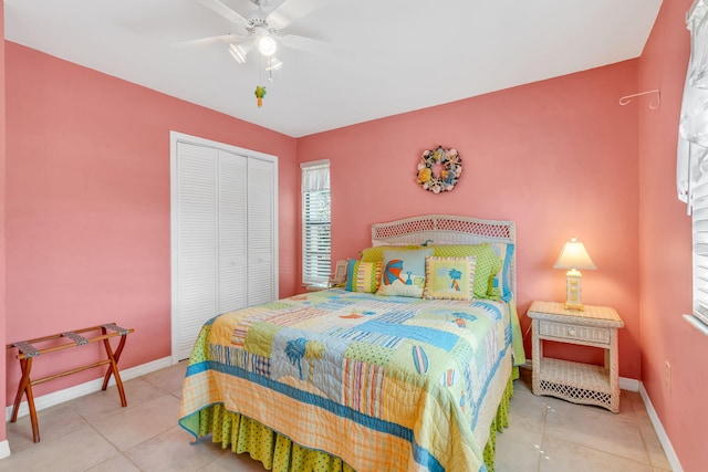 tiled bedroom with a ceiling fan, baseboards, and a closet