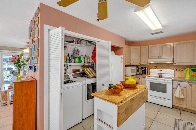 kitchen featuring visible vents, wood counters, washer and dryer, white appliances, and under cabinet range hood