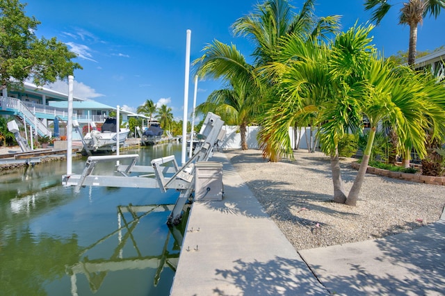 dock area featuring a water view, boat lift, and fence