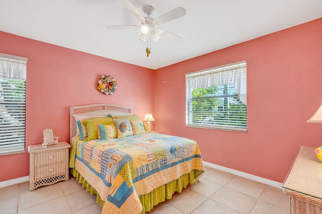 tiled bedroom featuring ceiling fan and baseboards