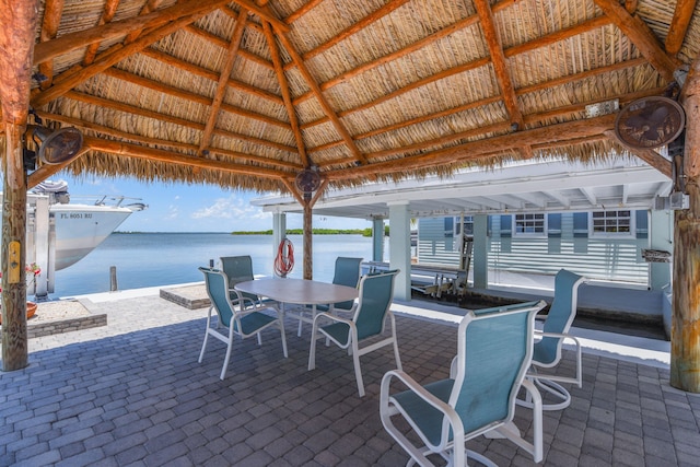 view of patio / terrace featuring a gazebo, outdoor dining space, and a water view