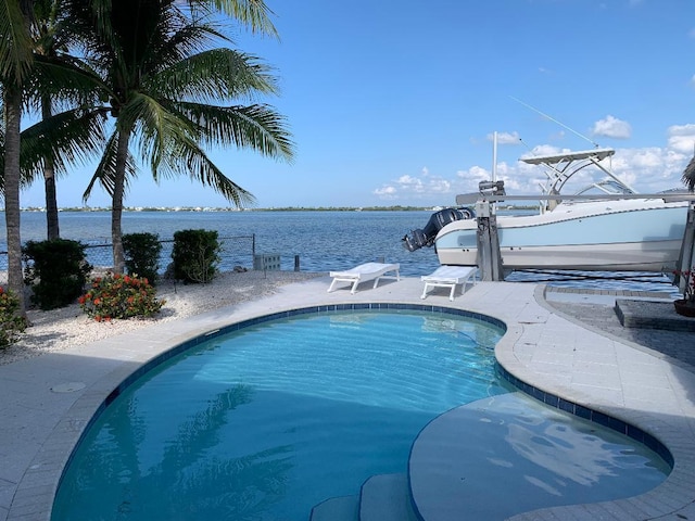 outdoor pool featuring a dock, a water view, and boat lift