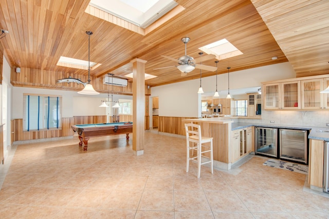 recreation room with light tile patterned floors, wooden ceiling, beverage cooler, a skylight, and wainscoting