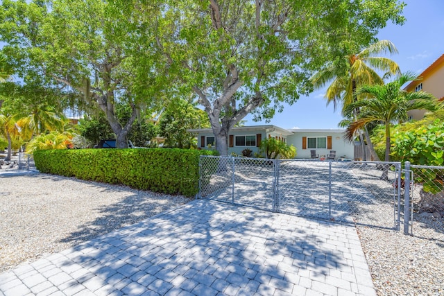 ranch-style house with a fenced front yard and a gate