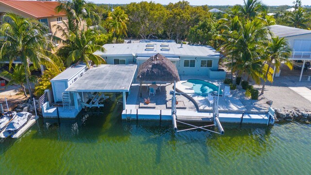 view of dock featuring a pool, a patio area, and a water view