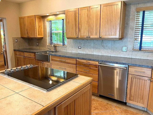 kitchen featuring tasteful backsplash, a sink, dishwasher, and black electric cooktop