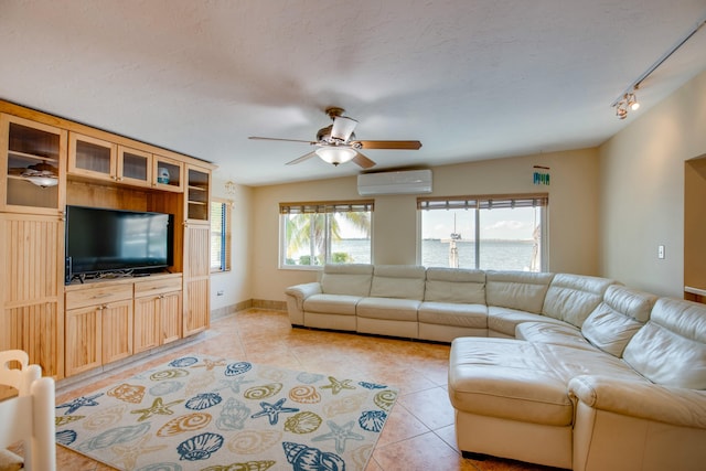 unfurnished living room with a wall mounted AC, a ceiling fan, light tile patterned flooring, a textured ceiling, and baseboards