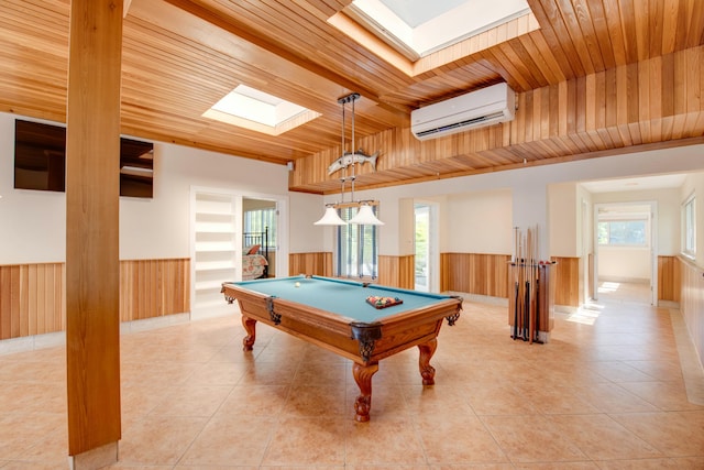 game room featuring a skylight, a wainscoted wall, light tile patterned floors, a wall mounted AC, and wooden ceiling