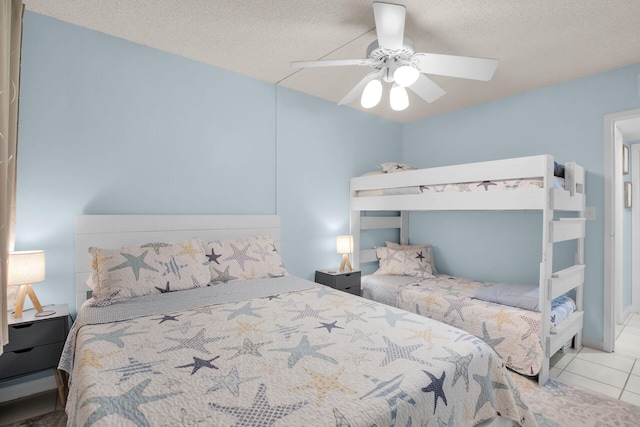 tiled bedroom with a textured ceiling and ceiling fan