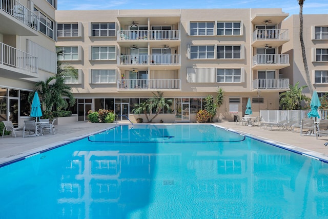 pool with a patio area, a ceiling fan, and fence