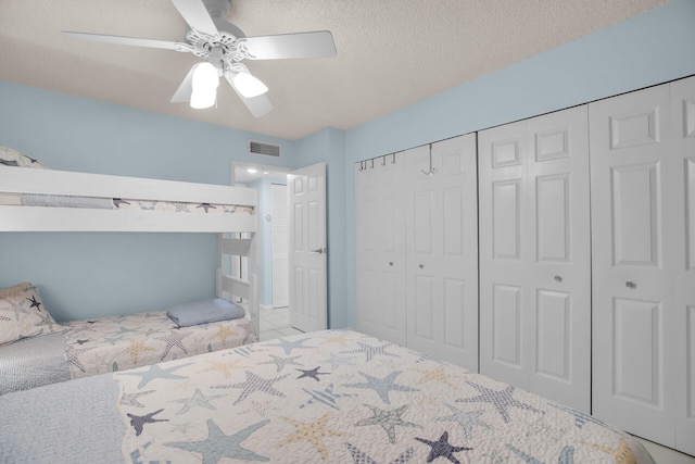 bedroom featuring a ceiling fan, visible vents, a closet, and a textured ceiling