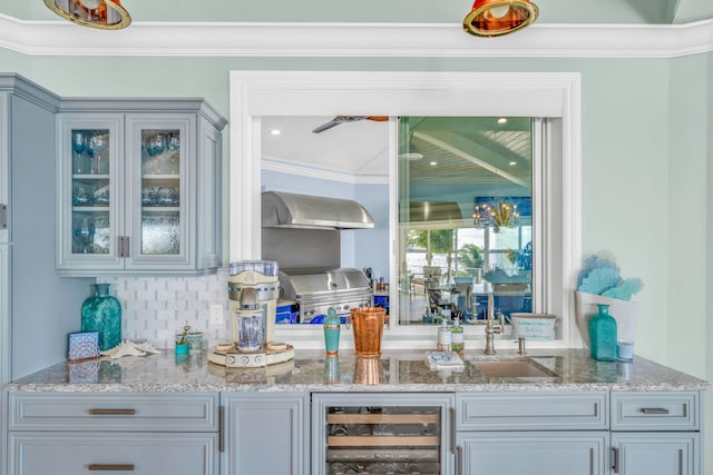 bar featuring ornamental molding, beverage cooler, sink, and wall chimney range hood