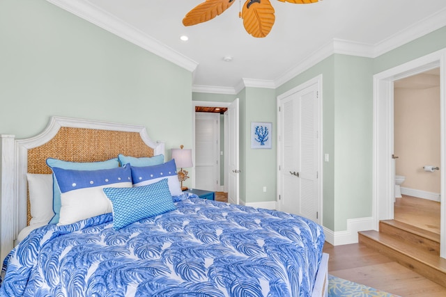 bedroom with crown molding, hardwood / wood-style floors, ceiling fan, and a closet