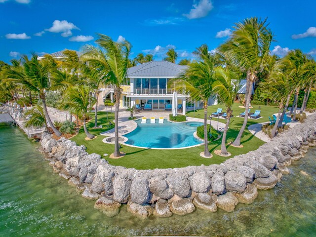 view of pool featuring a water view, a patio, and a lawn