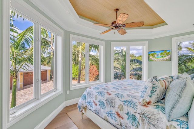 bedroom featuring crown molding, a tray ceiling, and multiple windows