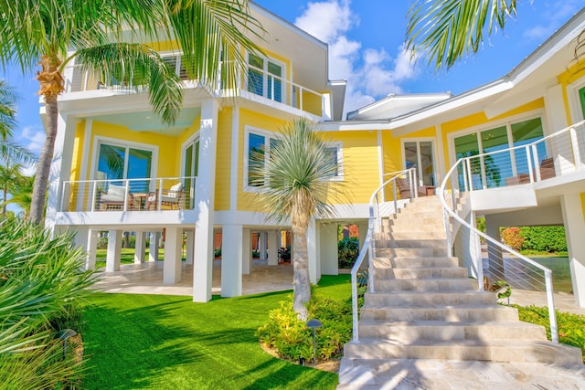 rear view of house featuring a yard and a patio area