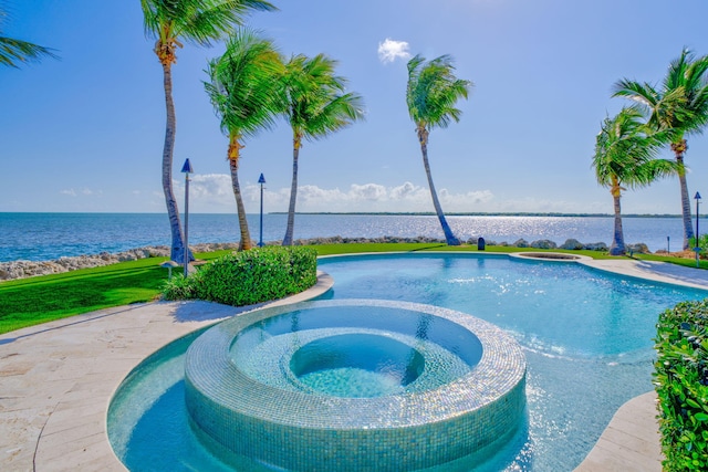 view of swimming pool with an in ground hot tub and a water view