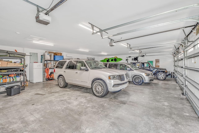 garage with a garage door opener and white fridge