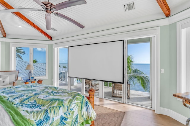 bedroom featuring multiple windows, a water view, access to exterior, and light wood-type flooring