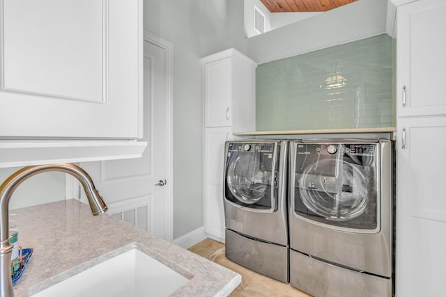 washroom featuring cabinets, independent washer and dryer, and sink