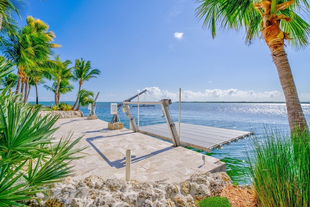 view of patio / terrace featuring a water view and a dock