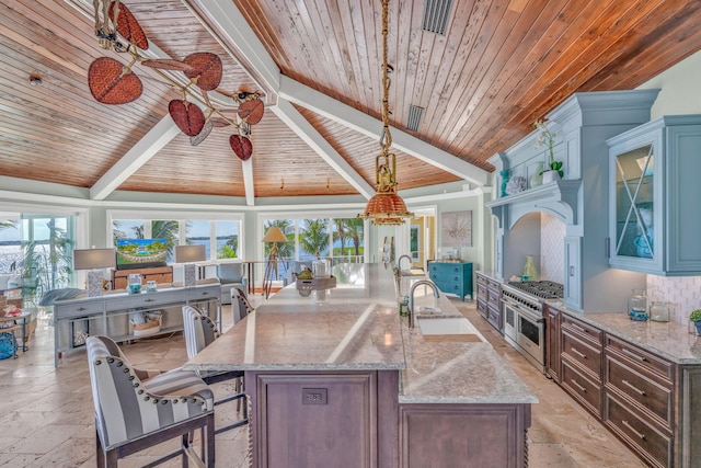 kitchen with lofted ceiling with beams, dark brown cabinets, double oven range, pendant lighting, and light stone countertops