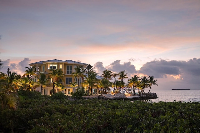 back house at dusk featuring a water view