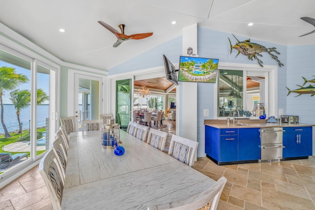 dining area featuring a healthy amount of sunlight, a water view, sink, and ceiling fan