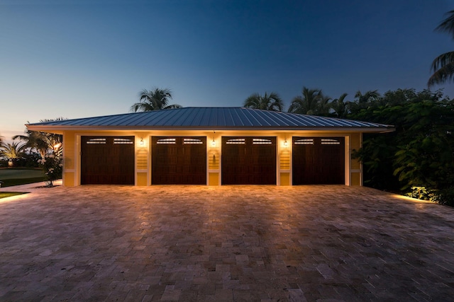 view of garage at dusk