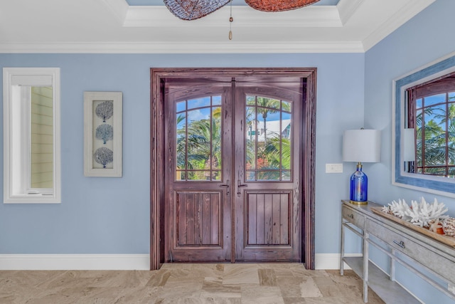 entryway with a tray ceiling and ornamental molding