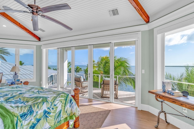 bedroom with access to exterior, light hardwood / wood-style floors, beamed ceiling, and a water view