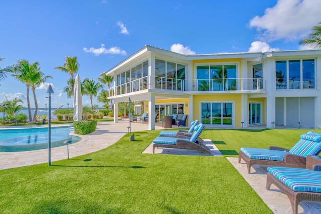 back of property featuring a patio area, a balcony, a yard, outdoor lounge area, and a sunroom