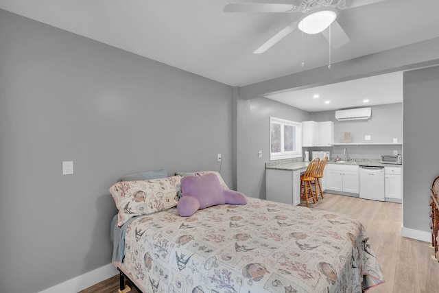 bedroom featuring sink, light hardwood / wood-style floors, a wall mounted AC, and ceiling fan