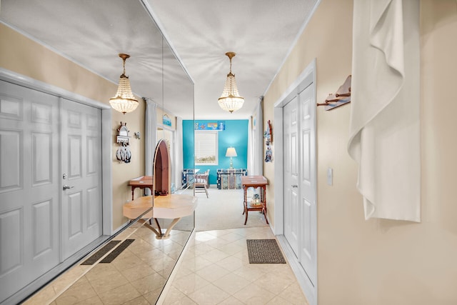 entrance foyer with light tile patterned floors and ornamental molding