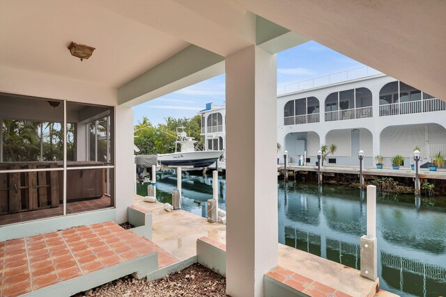 view of patio with a water view and a dock