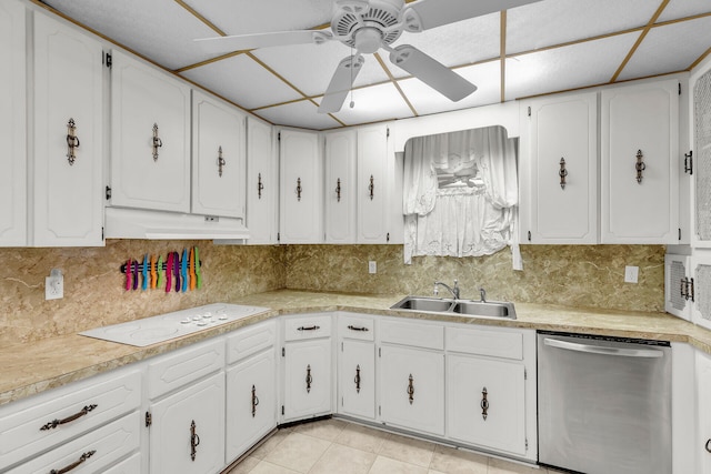 kitchen featuring sink, stainless steel dishwasher, white cabinets, and white stovetop