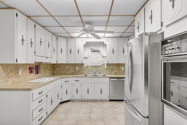 kitchen with stainless steel appliances, tasteful backsplash, sink, and white cabinets