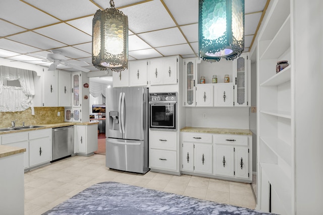 kitchen with sink, white cabinetry, a paneled ceiling, decorative light fixtures, and appliances with stainless steel finishes