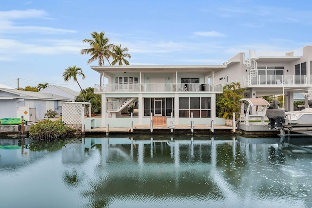 back of house with a sunroom and a water view