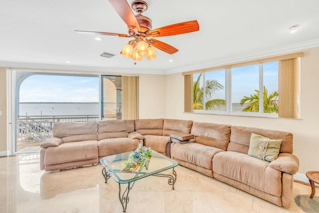 living room featuring a water view, ceiling fan, crown molding, and a wealth of natural light