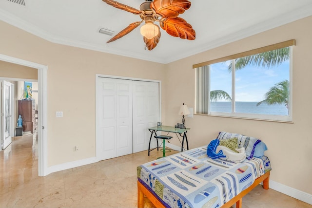 bedroom with crown molding, a closet, ceiling fan, and a water view