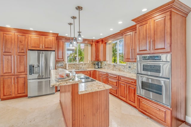 kitchen featuring pendant lighting, appliances with stainless steel finishes, a center island, light stone counters, and decorative backsplash