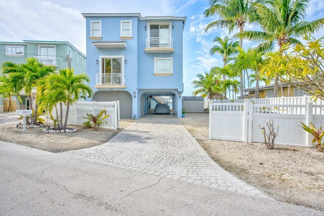 view of front of house with a carport, a balcony, and a water view