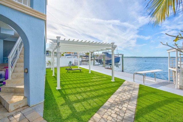 view of yard with a water view, a boat dock, and a pergola