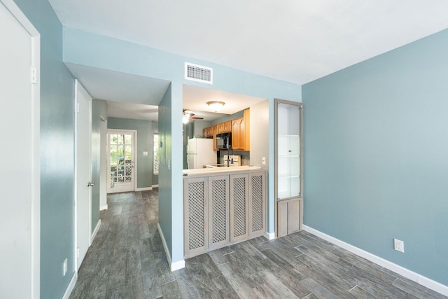 3314 Northside Dr Unit 145, Key West, FL 33040 - kitchen with black microwave, dark wood finished floors, freestanding refrigerator, ceiling fan, and light countertops