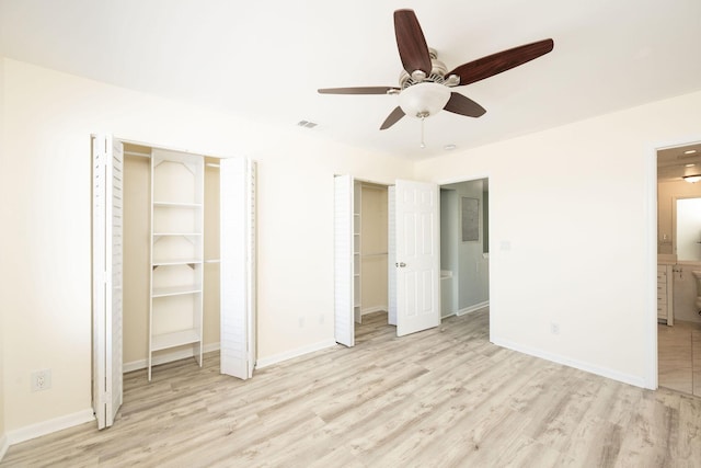 3314 Northside Dr Unit 145, Key West, FL 33040 - unfurnished bedroom featuring light wood-style floors, connected bathroom, ceiling fan, and two closets