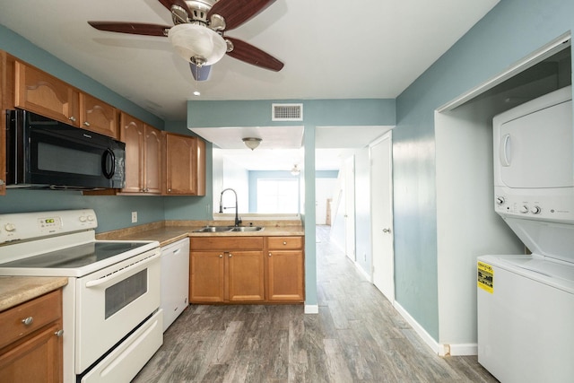 3314 Northside Dr Unit 145, Key West, FL 33040 - kitchen with white appliances, stacked washer and clothes dryer, wood finished floors, light countertops, and brown cabinets